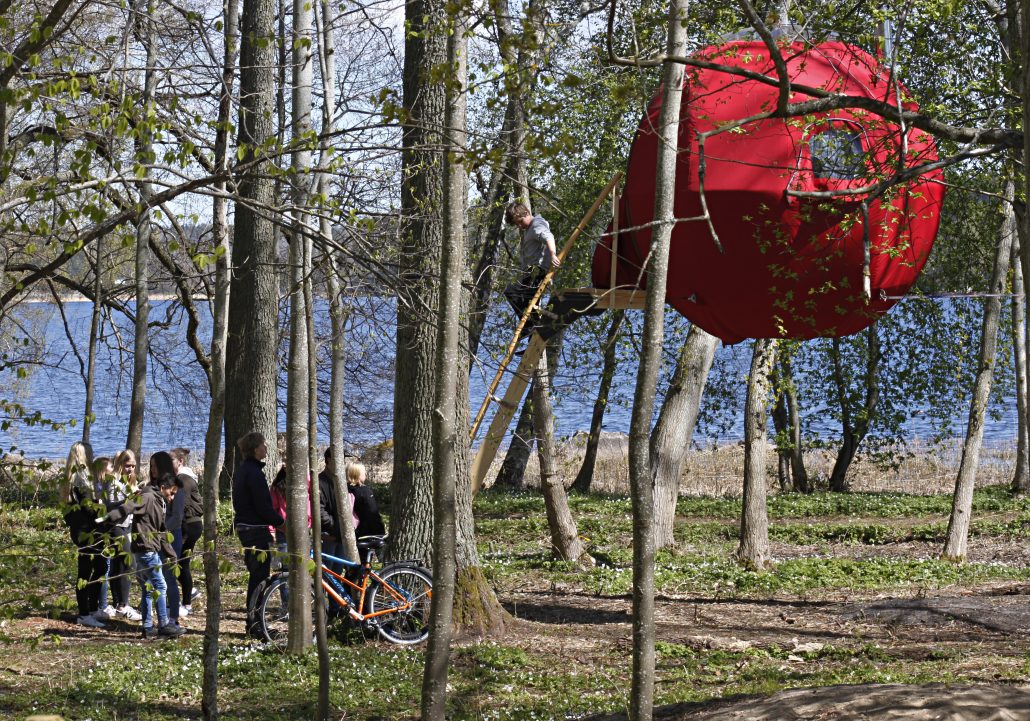 Kids climbing up to red Tree Tent