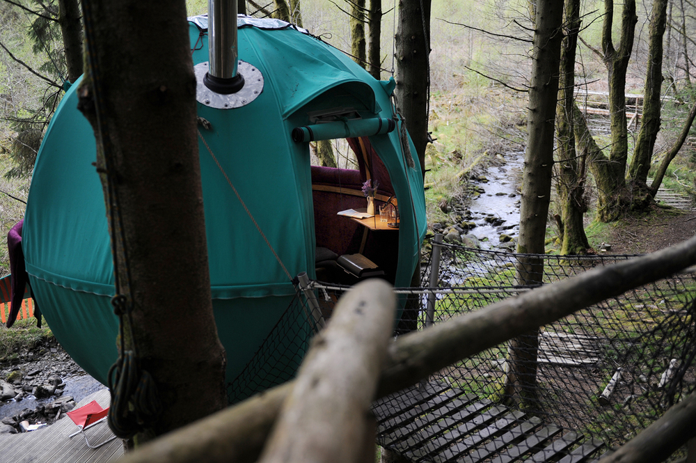 Looking out across a green Tree Tent to stream